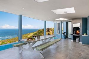 a dining room with a table and a view of the ocean at Knysna, Pezula Golf Estate in Knysna