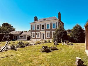 une grande maison avec une cour herbeuse devant elle dans l'établissement L'Orée d'Etretat, à La Poterie-Cap-dʼAntifer