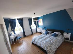 une chambre avec des murs bleus et un lit et un bureau dans l'établissement L'Orée d'Etretat, à La Poterie-Cap-dʼAntifer 36 autres photos
