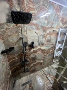 a shower in a bathroom with a stone wall at Rinn Residence in Iaşi +32 photos