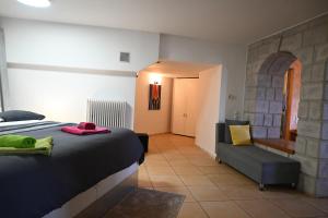 ein Schlafzimmer mit einem Bett, einer Couch und einem Sessel in der Unterkunft Tranquil Infinity Pool Getaway (private jacuzzi and steam bath, pool, garden, sea and city views) in Volos + 47 Fotos