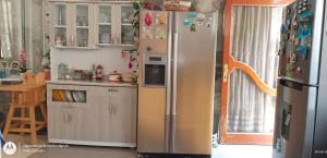 eine Küche mit einem Kühlschrank mit vielen Magneten daran in der Unterkunft Casa cerca a la playa in Mala