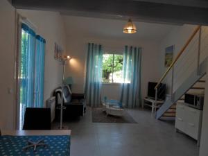 a living room with blue curtains and a staircase at Les Hauts d'Eyragues gîte Aigue Marine Meublé classé 4 étoiles in Eyragues +23 photos
