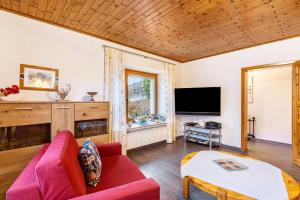 a living room with a red couch and a tv at Haus Stanek in Willingen