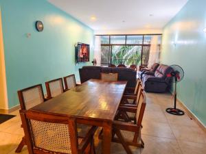a living room with a wooden table and chairs at Zahra Paradise in Mombasa