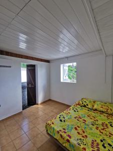 a bedroom with a bed and a window at KazCoco Marie-Galante in Saint-Louis