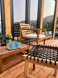 a porch with two chairs and tables on a balcony at Mountain Log Cabin in Mavrovo