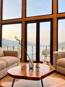 a living room with a coffee table in front of windows at Mountain Log Cabin in Mavrovo +78 photos