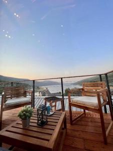 a wooden deck with two benches and a table at Mountain Log Cabin in Mavrovo