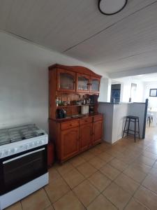 a kitchen with wooden cabinets and a stove at KazCoco Marie-Galante in Saint-Louis
