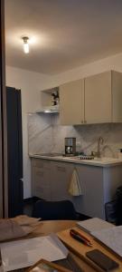 a kitchen with white cabinets and a table and a counter at Appartement Lanton in Lanton