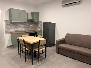 une cuisine avec une table, des chaises et un canapé dans l'établissement Emmeci House, à Alghero