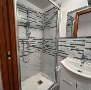une salle de bain avec douche et lavabo dans l'établissement Emmeci House, à Alghero