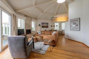 a living room with a couch and a tv at Golfvilla 38 in Hollum