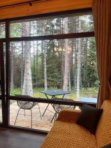a living room with a large window with a table and chairs at Zarevo Glamping Forest Houses in Skobelevo