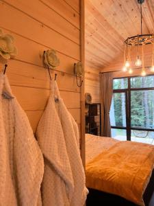 a bedroom with a bed in a wooden wall at Zarevo Glamping Forest Houses in Skobelevo +12 photos