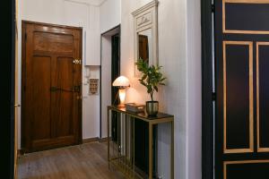 a hallway with a door and a table with a plant on it at Glamour Jacuzzi Privé Chambéry in Chambéry