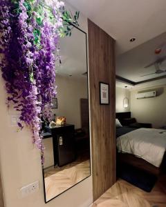 a room with a mirror with purple flowers on the wall at Omaxe trade centre alpha 2 in Greater Noida