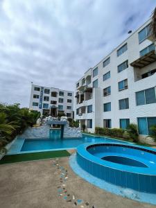 un hôtel avec une piscine devant un bâtiment dans l'établissement Apartamento grande enfrente del océano, à Tonsupa