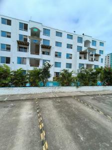 un parking vide devant un grand bâtiment dans l'établissement Apartamento grande enfrente del océano, à Tonsupa