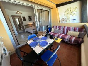 Appt Studio 2 couchages CAP D'AGDE NATURISME في كاب داغد: غرفة معيشة مع طاولة وكراسي وأريكة