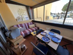 Appt Studio 2 couchages CAP D'AGDE NATURISME في كاب داغد: غرفة بها طاولة وكراسي وأريكة +11 صورة