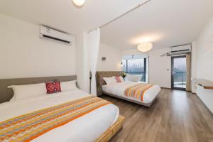 a bedroom with two beds and a balcony at Ruyuan Riverside Boutique Hotel in Chongqing