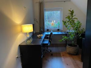 an office with a desk with a lamp and a window at Ferienwohnung Lang in Nümbrecht