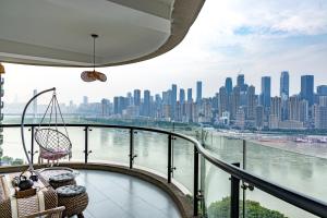 a balcony with chairs and a view of a city at Ruyuan Riverside Boutique Hotel in Chongqing