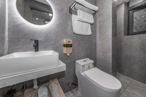 a bathroom with a sink and a toilet and a mirror at Ruyuan Riverside Boutique Hotel in Chongqing +37 photos