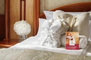a pile of towels and a book on a bed at Hotel Fürstenhof Bad Bertrich in Bad Bertrich