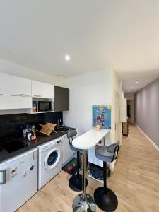 a kitchen with a table and a white counter top at Harmony in Limonest