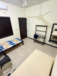 a room with a bed and a chair in it at SSF Green Home in Akkaraipattu