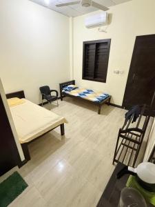 a room with a bed and two chairs in it at SSF Green Home in Akkaraipattu