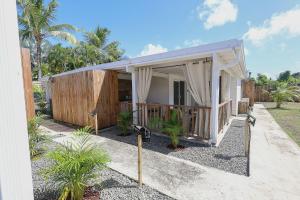 a small white house with a fence and trees at L'Escapade Créole in Saint-François