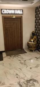 a lobby with a brown door and a chair in front of it at aluxor hotel and Restaurant in Kharar
