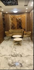 a lobby with a couch and tables in a room at aluxor hotel and Restaurant in Kharar