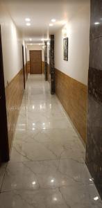 a hallway of a building with a tile floor at aluxor hotel and Restaurant in Kharar