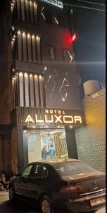 a black car parked in front of a hotel at aluxor hotel and Restaurant in Kharar