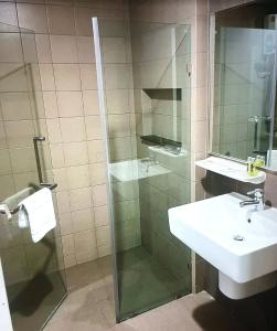 ein Badezimmer mit Glasdusche und Waschbecken in der Unterkunft Home sweet home in Phra Khanong