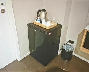 ein kleiner schwarzer Kühlschrank in der Ecke eines Zimmers in der Unterkunft Home sweet home in Phra Khanong