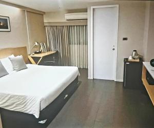 Schlafzimmer mit einem Bett, einem Schreibtisch und einem Telefon in der Unterkunft Home sweet home in Phra Khanong + 7 Fotos