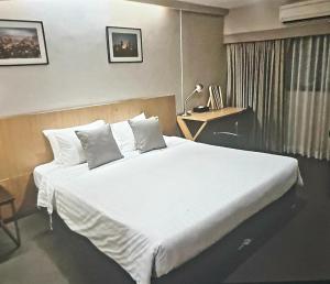Schlafzimmer mit einem großen weißen Bett und einem Schreibtisch in der Unterkunft Home sweet home in Phra Khanong