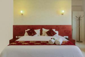 a bedroom with a large bed with two pillows at Hotel Metropolitan in Jaipur