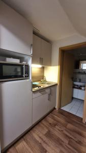 a kitchen with white cabinets and a microwave at Family & Business Apartment Erlangen, Siemens & Uni Nähe in Erlangen