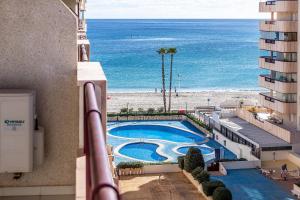a view of a pool and the beach from a building at Apartamentos Topacio Unitursa in Calpe