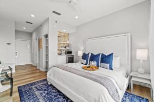 a white bedroom with a large bed with blue pillows at Inn at Seacrest Beach 409 in Inlet Beach