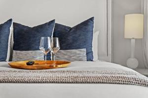 two wine glasses and a tray on a bed at Inn at Seacrest Beach 409 in Inlet Beach