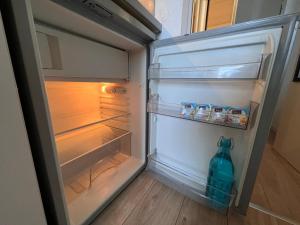 an open refrigerator with a bottle of water in it at Appart'Hotel - Gare TGV - Courtine - Confluence - 407 bis in Avignon