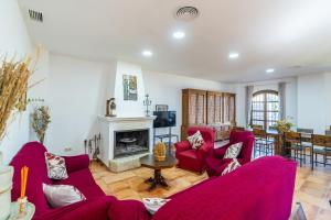 a living room with red couches and a fireplace at Cubo's Casa Rural Cortijo del Puntal in Teba